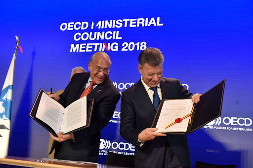 EL Expresidente Juan Manuel Santos y José Ángel Gurría, Exsecretario General, en el concejo ministerial de la OCDE, recibe y muestra la invitación a ser miembro.