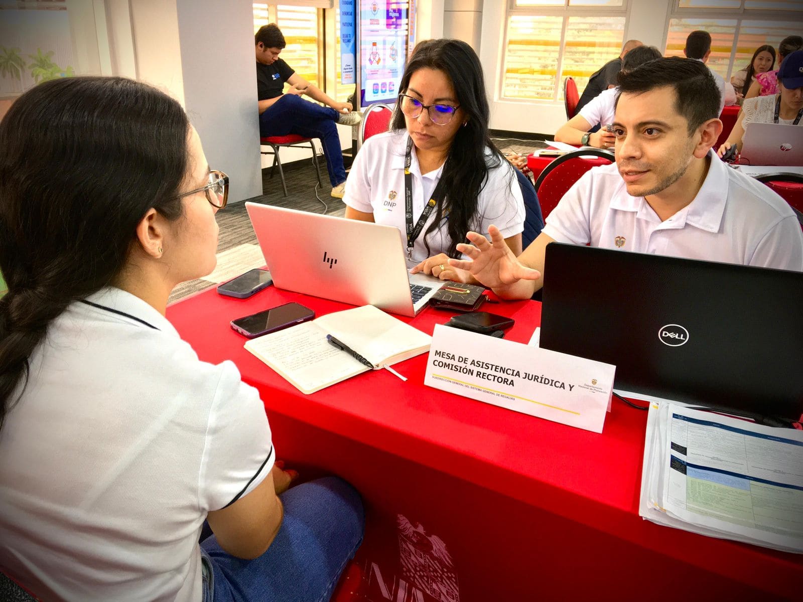 Equipo de colaboradores del DNP atienden a mujer joven en las mesas de asistencia en el Meta