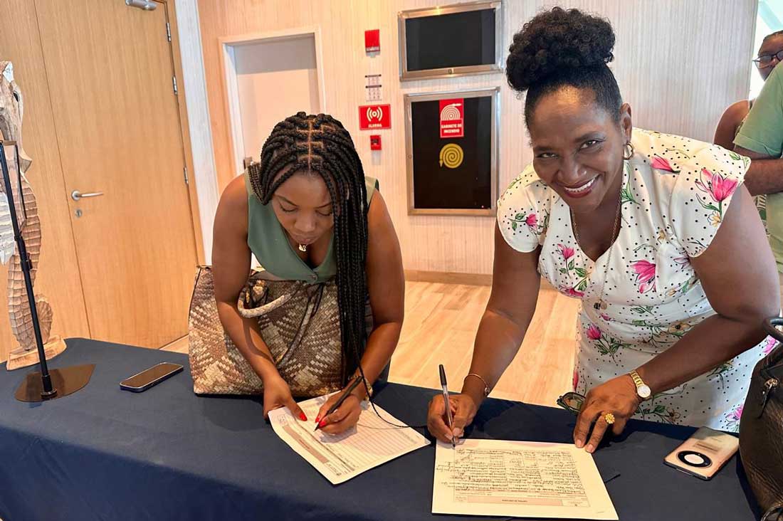 Mujeres afrocolombianas firmando lista de asistencia sonrien a la cámara