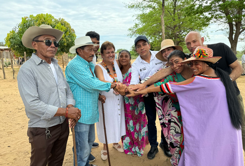 Grupo de personas de la comunidad durante la Misión Guajira del DNP, unidas en un gesto de colaboración y apoyo. 